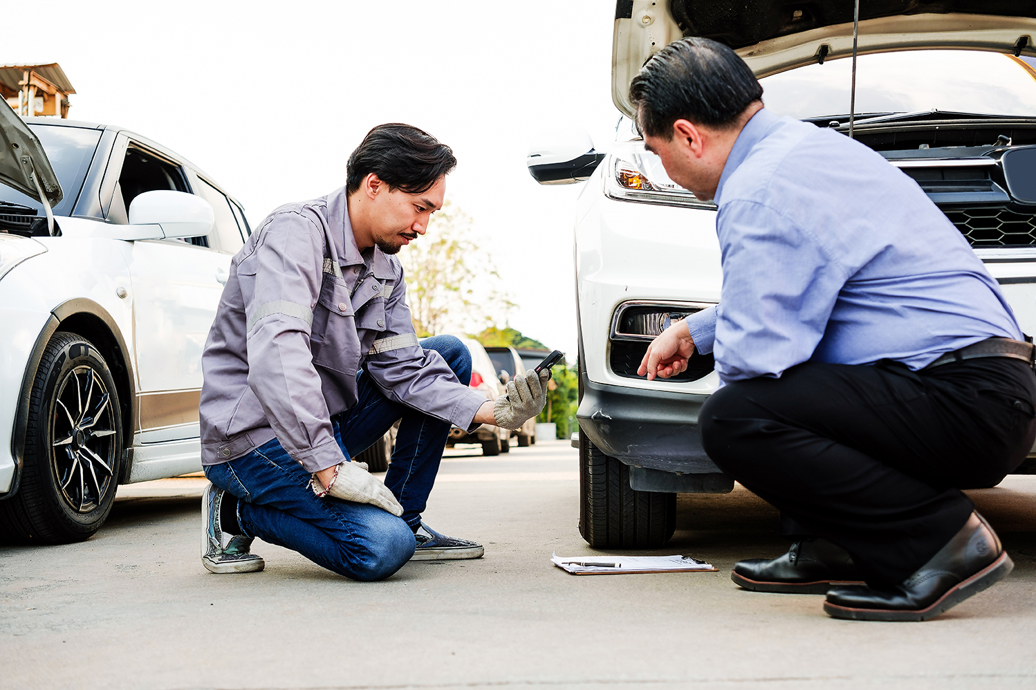 A technician repairing a car on the roadside.
