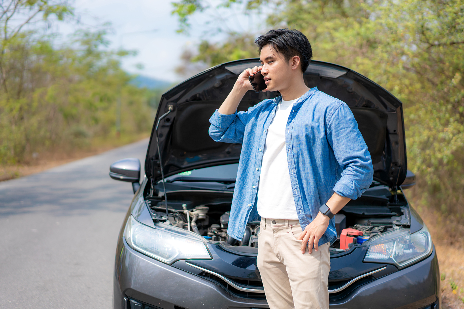 Man calling for emergency roadside assistance.