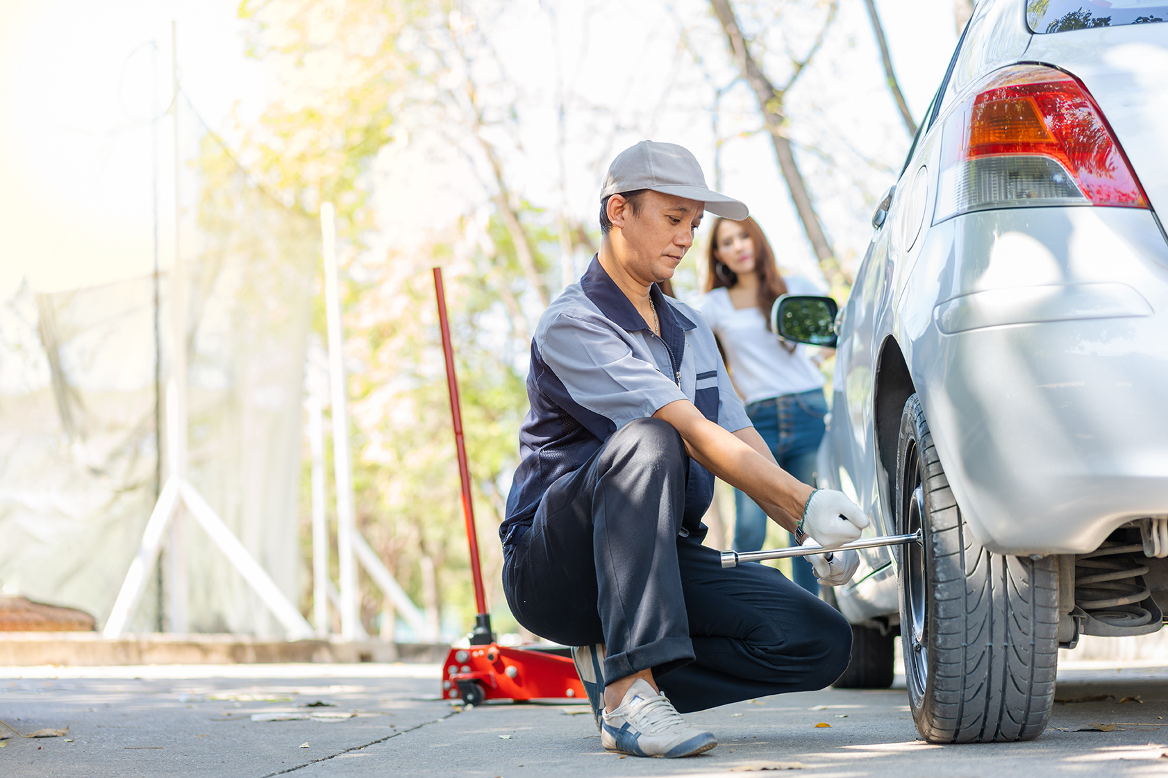 A mechanic repairing a car on a roadside.